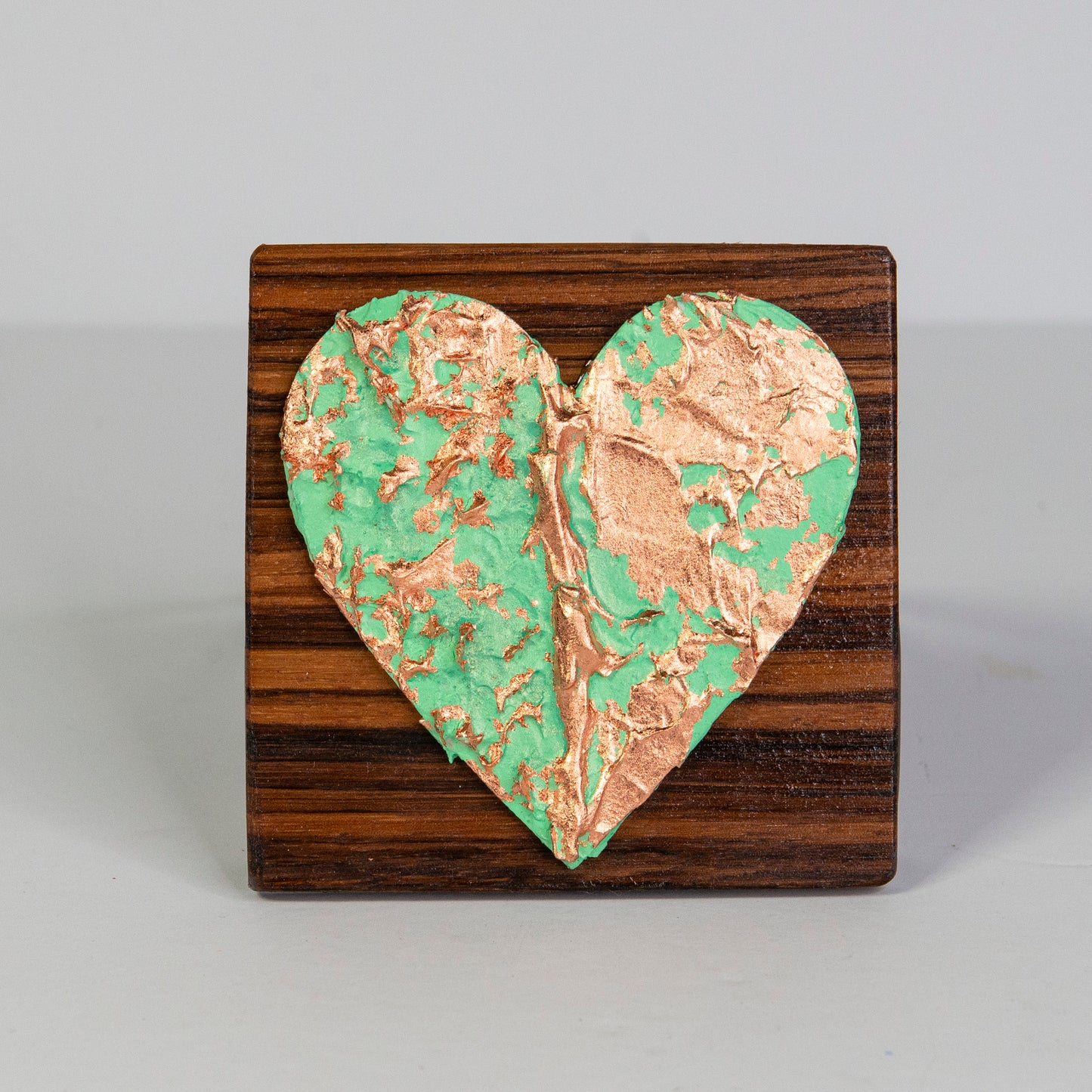 Metal art heart on wood