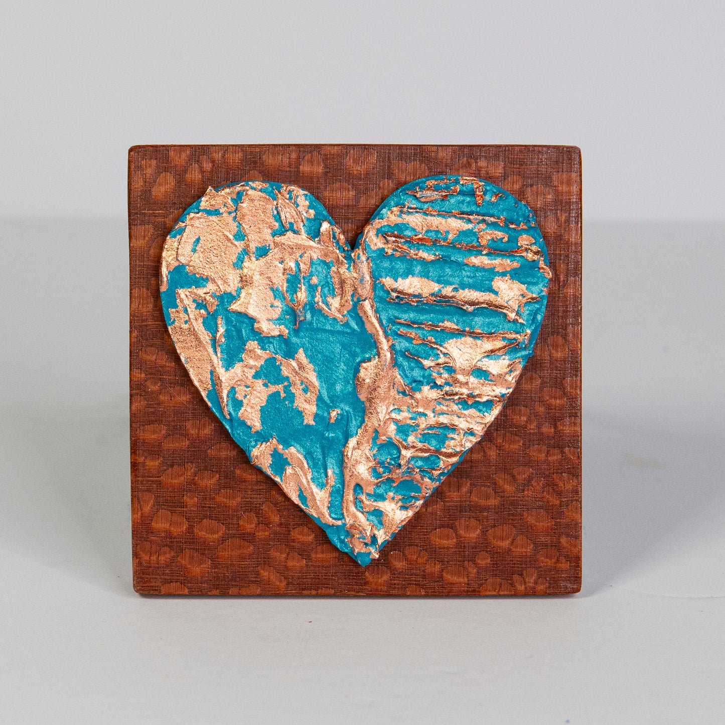 Metal art heart on wood